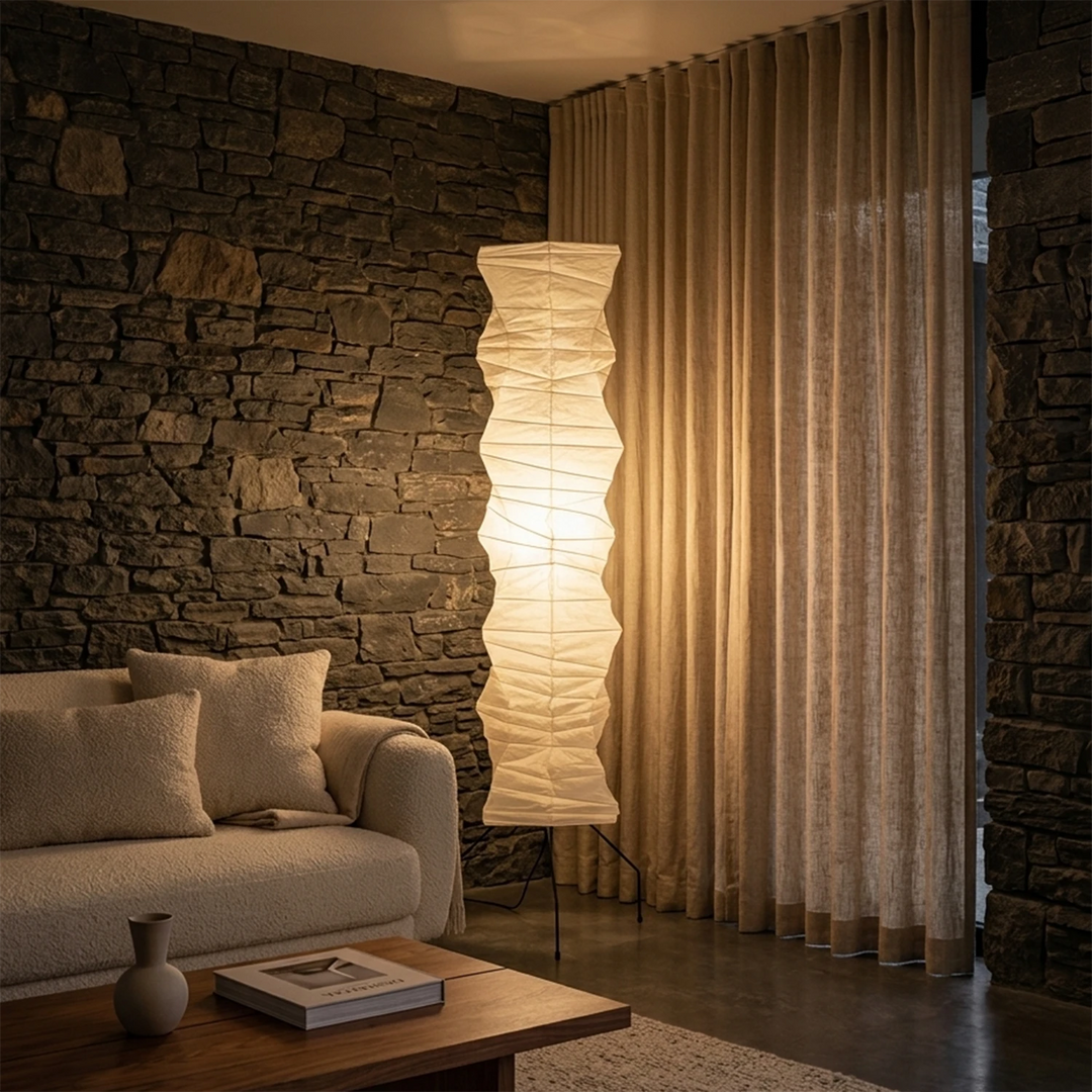 Paper floor lamp against a rough stone wall in a warm living area