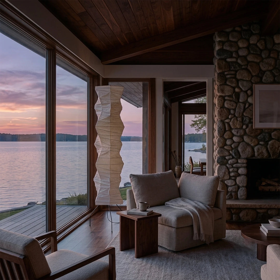 Pleated paper floor lamp in a lakeside lounge with timber ceiling and stone fireplace