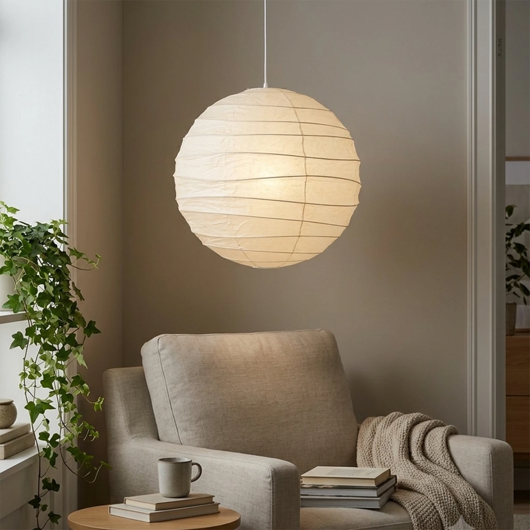 Paper pendant glowing above a reading chair in a quiet corner nook