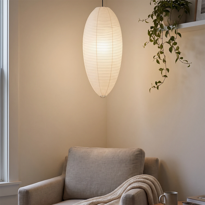 Oval paper pendant above a cozy reading corner with a draped throw