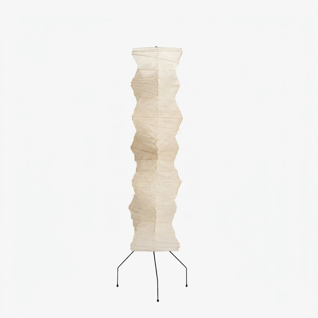 Tall sculptural paper floor lamp with black tripod base on a soft grey background