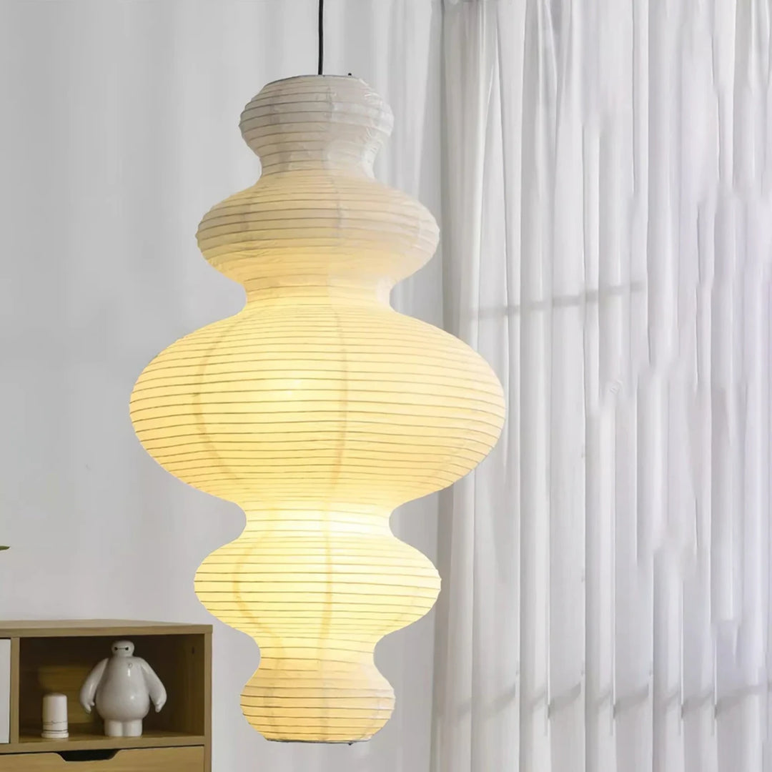 Sculptural paper pendant beside curtains above a small styled console