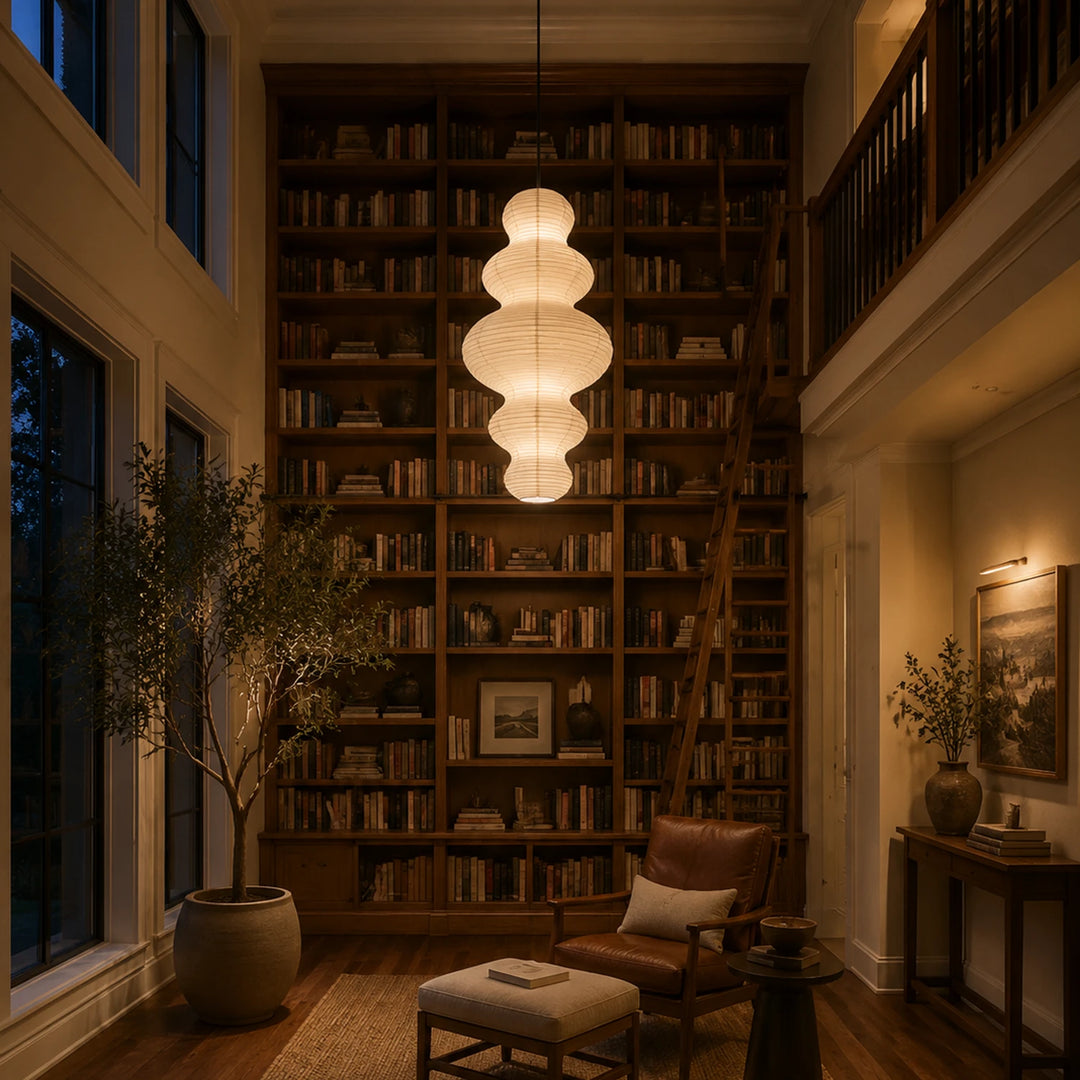 Sculptural paper pendant in a book-lined home library at evening