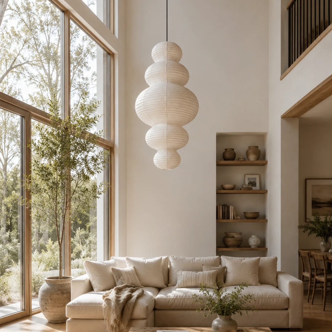 Sculptural paper pendant in a living room beside a cream sofa and shelving