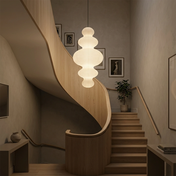 Sculptural paper pendant hung over a curved staircase landing