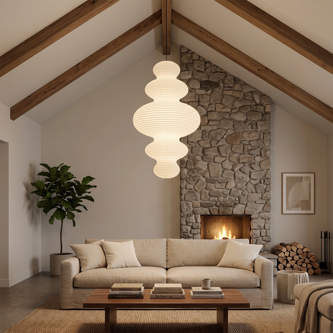 Sculptural paper pendant in a vaulted lounge above a stone fireplace