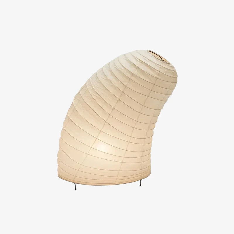 Shell-shaped paper table lamp shown lit against a pale grey studio backdrop