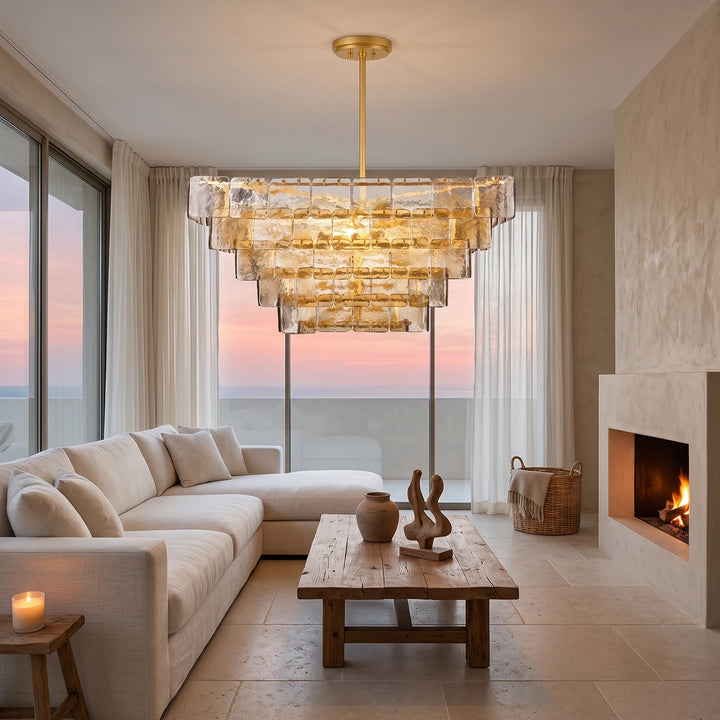 Smoked glass chandelier glowing at dusk in a living room with a wide window