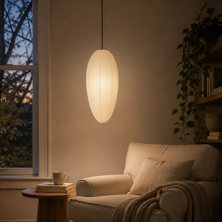 Oval paper pendant glowing beside a sofa and small round side table