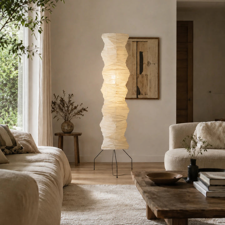 Paper floor lamp diffusing soft light in a lounge corner with a wooden bench