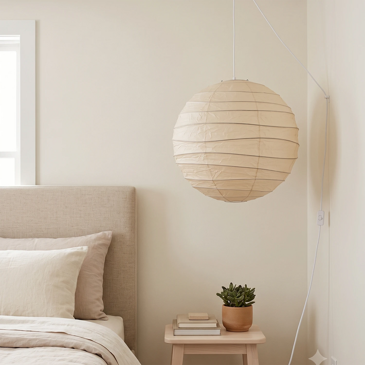 Paper pendant diffusing soft light in a calm neutral bedroom