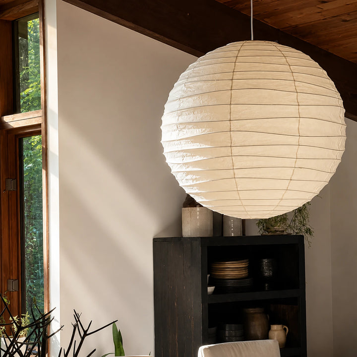 Sphere paper pendant hanging from a vaulted timber ceiling in a bright lounge