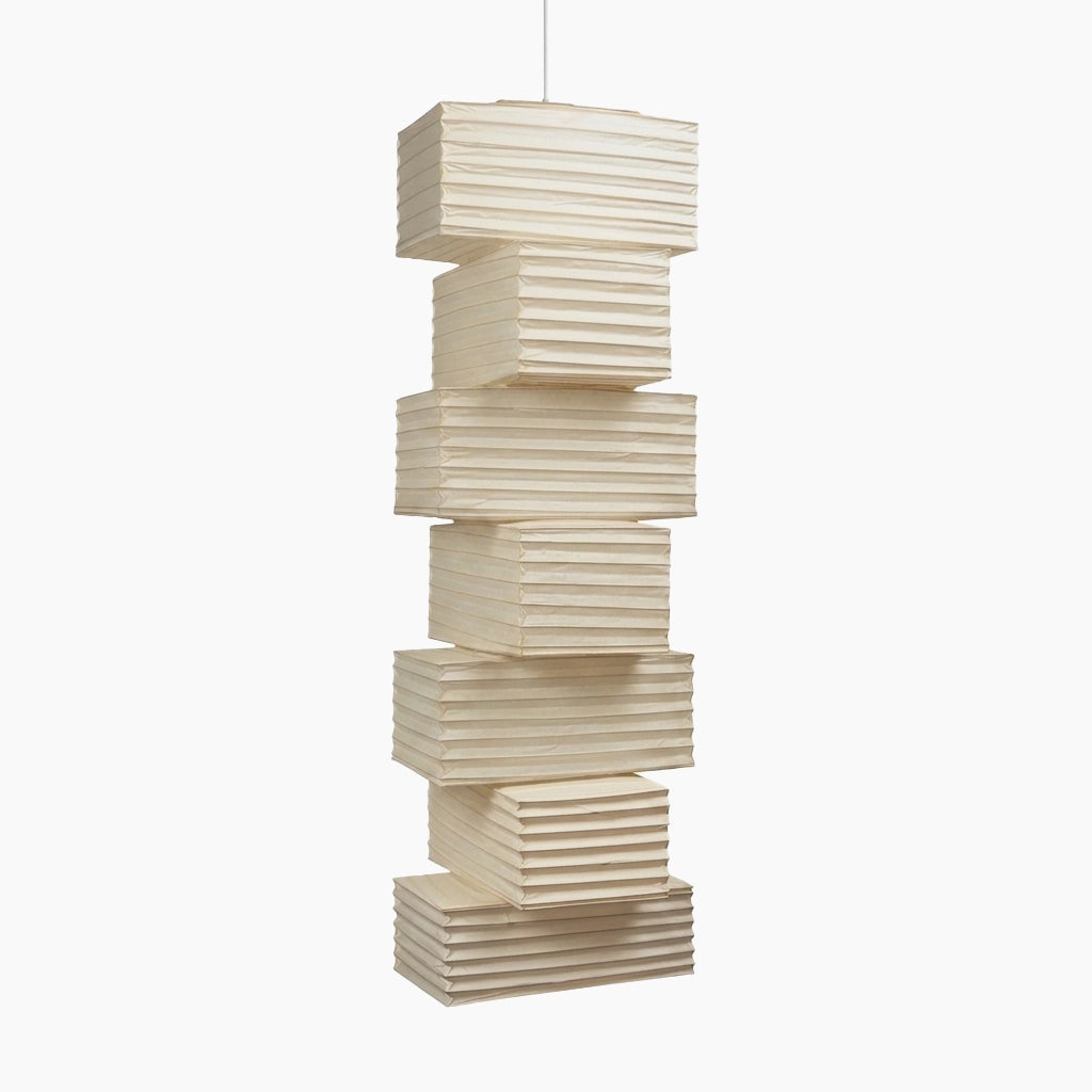 Tall paper pendant light built from offset stacked block segments, shown unlit on a light gray background