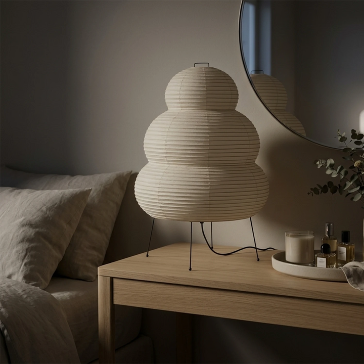 Stacked paper table lamp glowing warm beside a stacked firewood nook