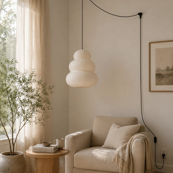 Stacked paper pendant beside an armchair in a bright window corner