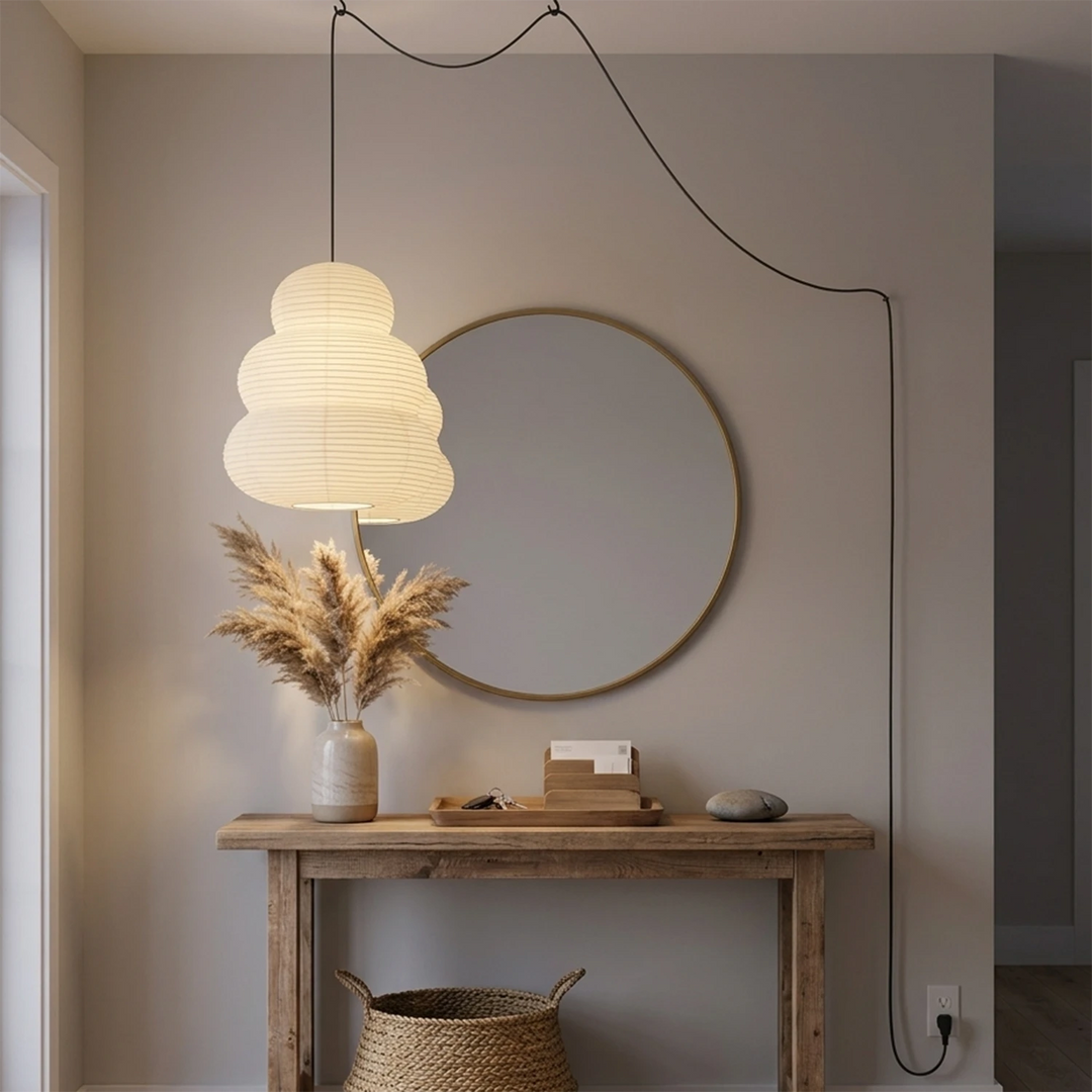 Stacked paper pendant above a console beneath a round mirror