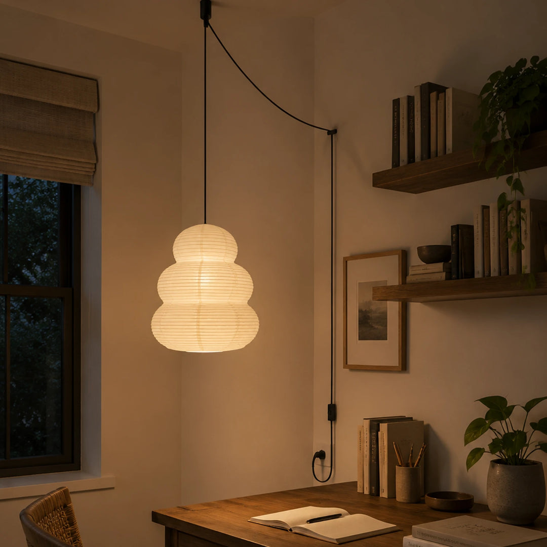Stacked paper pendant on a swag cord above a wooden desk nook