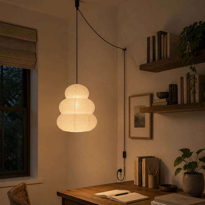 Stacked paper pendant on a swag cord above a wooden desk nook