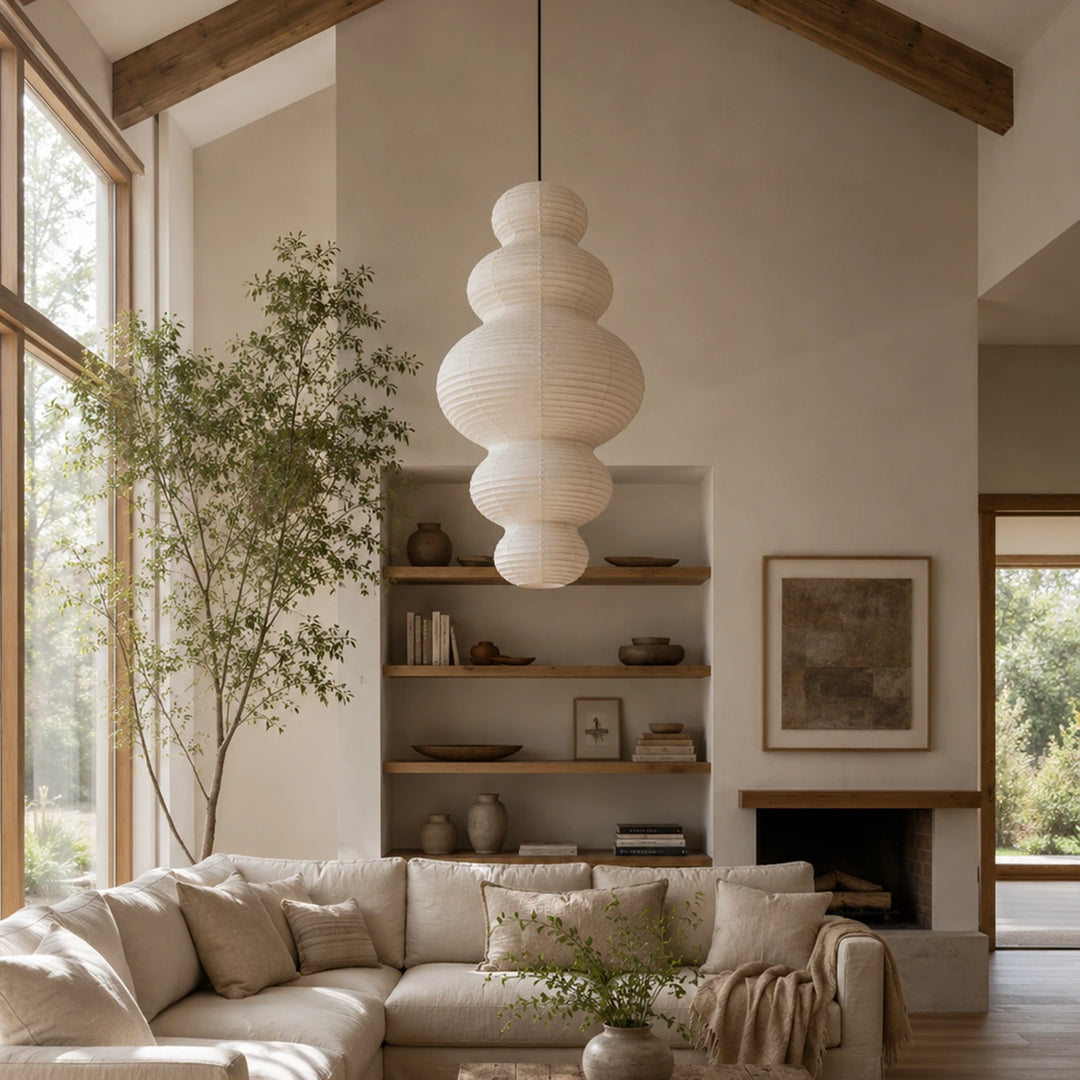 Stacked paper pendant in a double-height living room beside tall windows