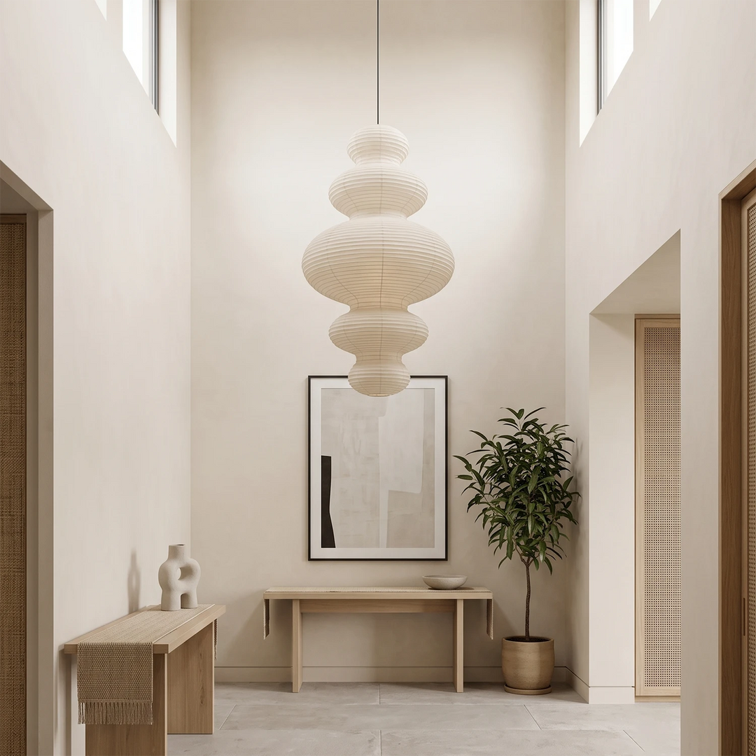 Stacked paper pendant in an entryway above a console and framed art