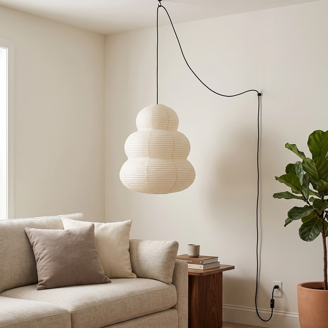 Stacked paper pendant beside a linen sofa in a bright living room