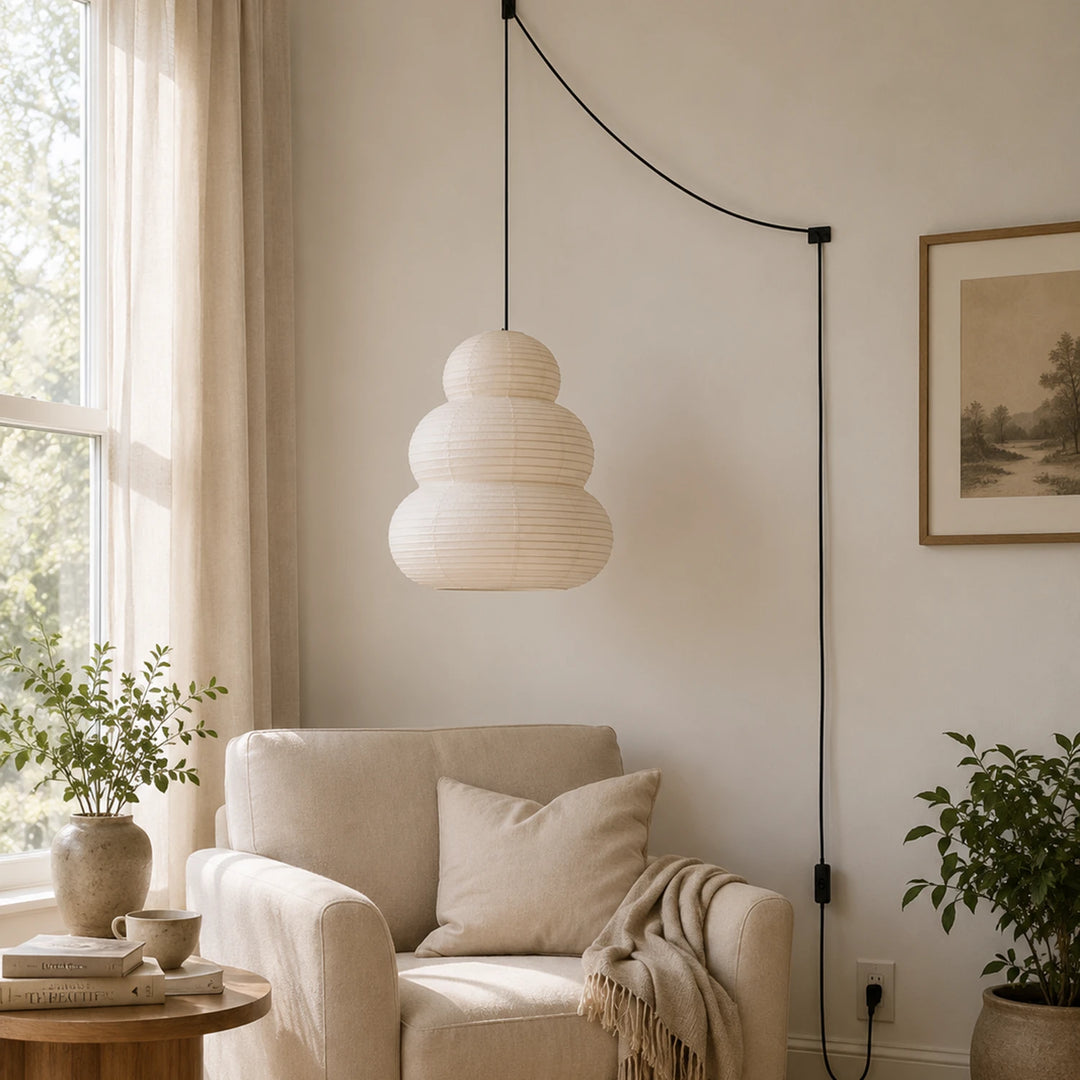 Stacked paper pendant in a sunlit living room beside layered seating