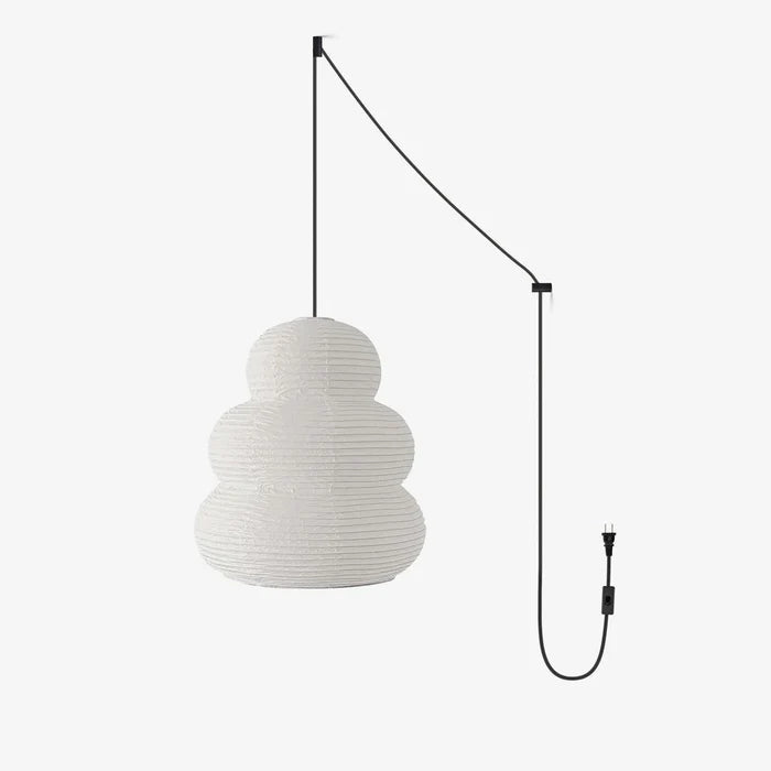 Stacked paper pendant on a black swag cord with plug, shown unlit