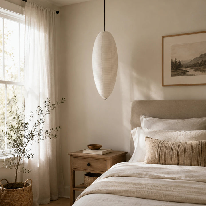 Oval paper pendant hung as a vertical drop beside a staircase