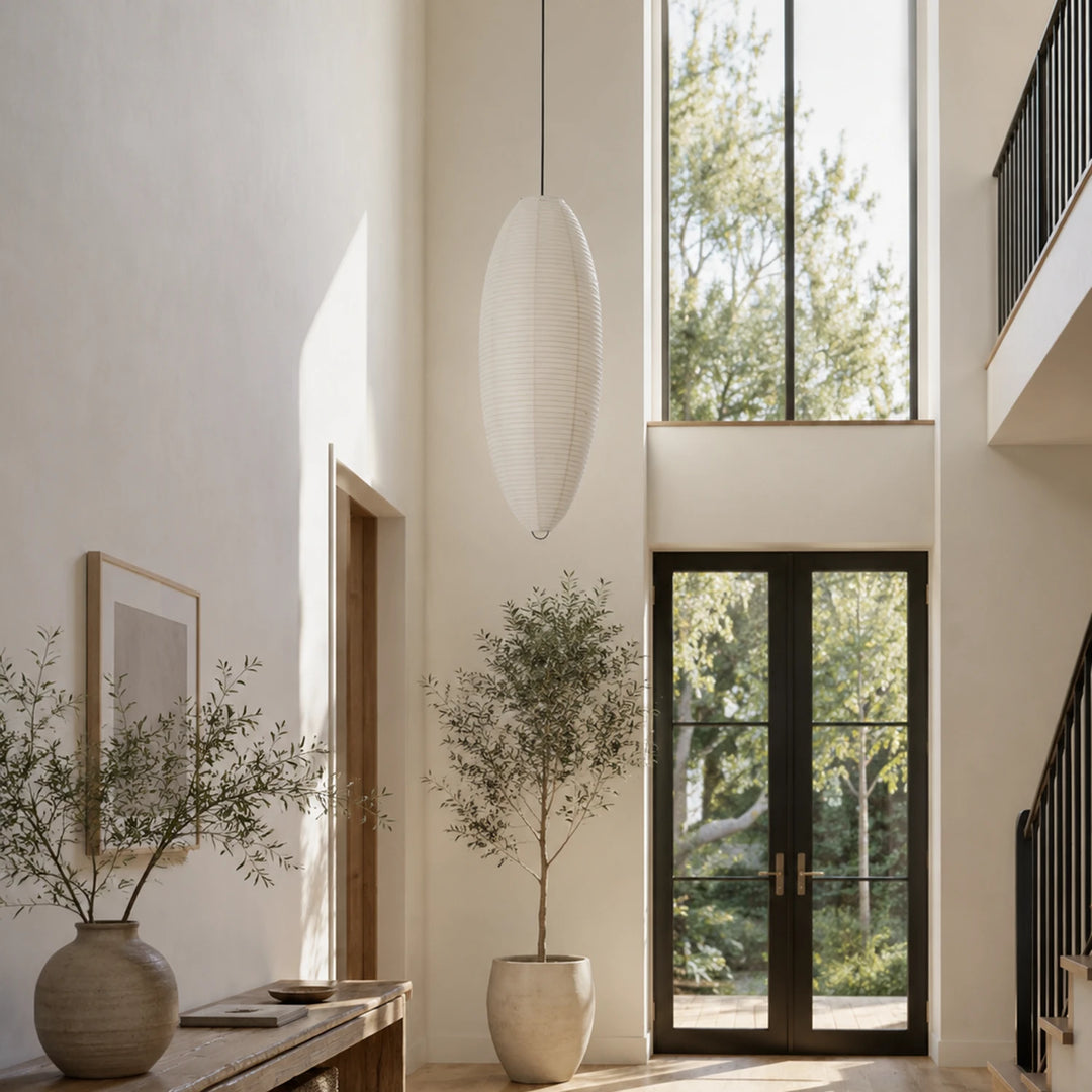 Oval paper pendant beside a tall window against a warm plaster wall