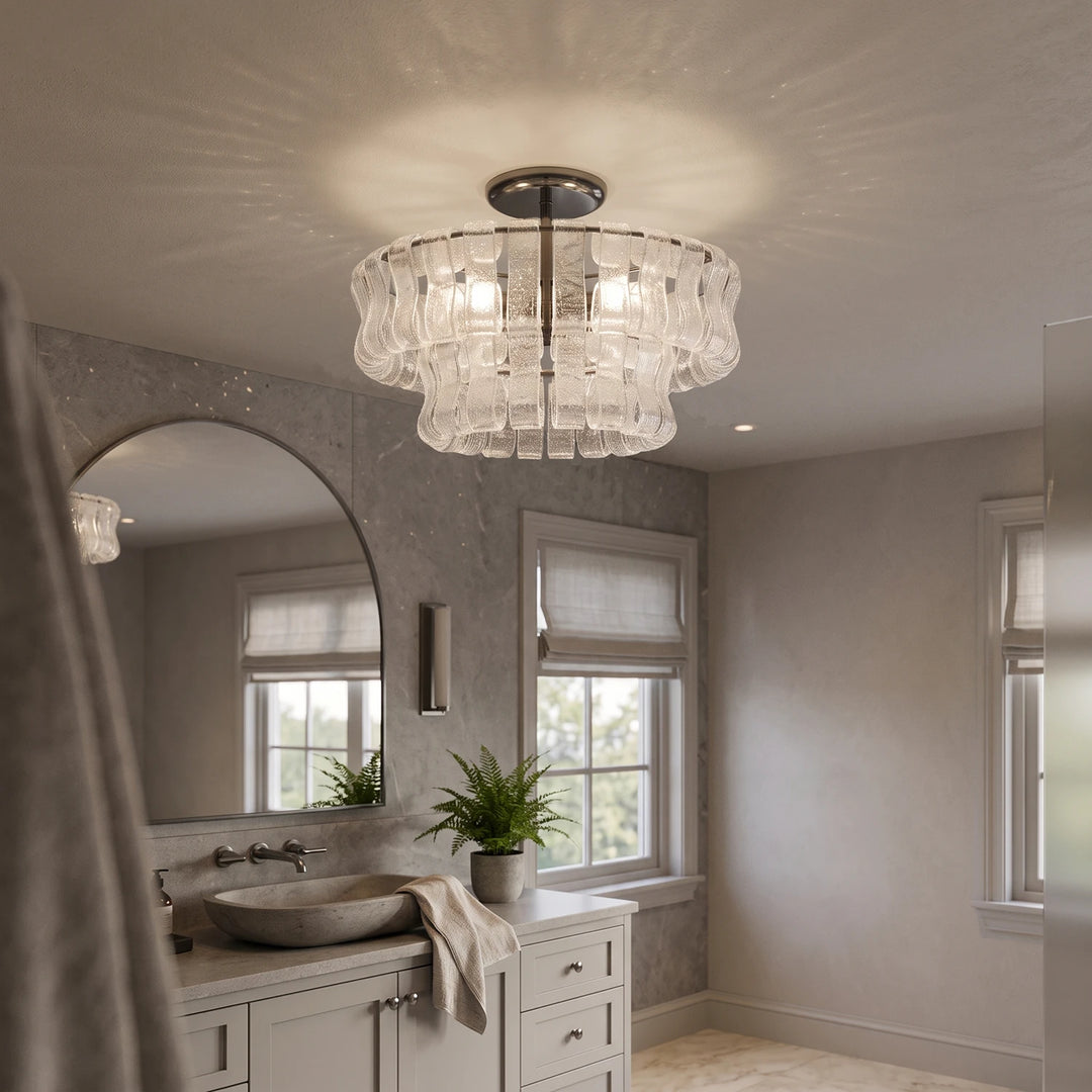 Tiered glass ceiling light above a bathroom vanity with an arched mirror and stone basin
