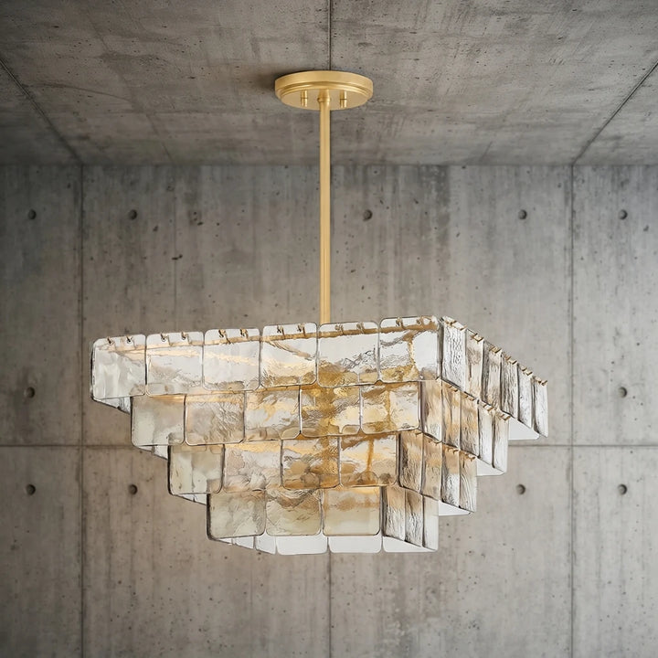 Tiered glass chandelier mounted to a concrete ceiling, seen from below the stem