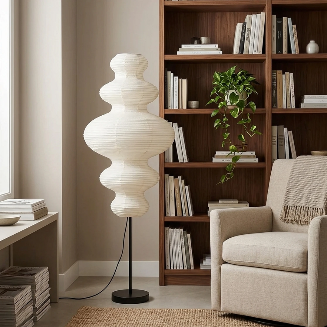 Tiered gourd paper floor lamp in a reading nook beside a wooden bookcase