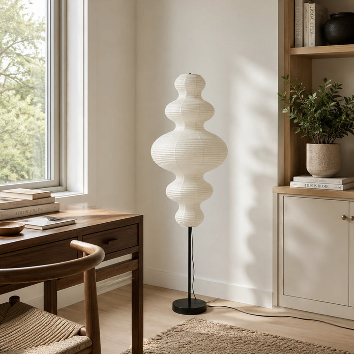 Tiered gourd paper floor lamp beside a wooden desk in a study corner