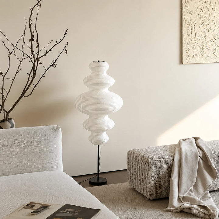 Tiered gourd paper floor lamp in a neutral living room beside a linen sofa