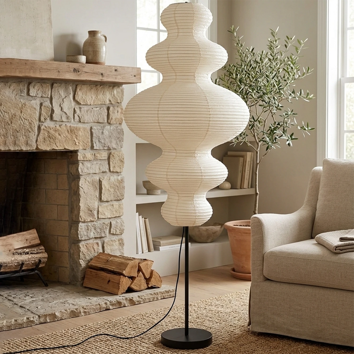 Tiered gourd paper floor lamp beside a stone fireplace in a warm living room