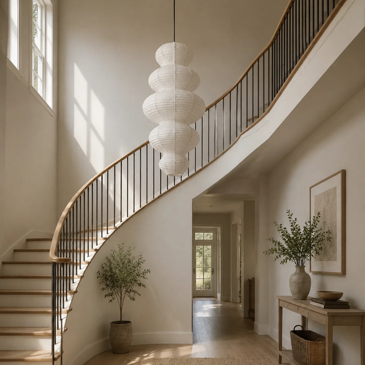 Tiered gourd paper pendant hung beside a sweeping curved staircase