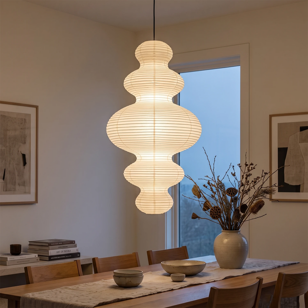 Tiered gourd paper pendant glowing above a wooden dining table