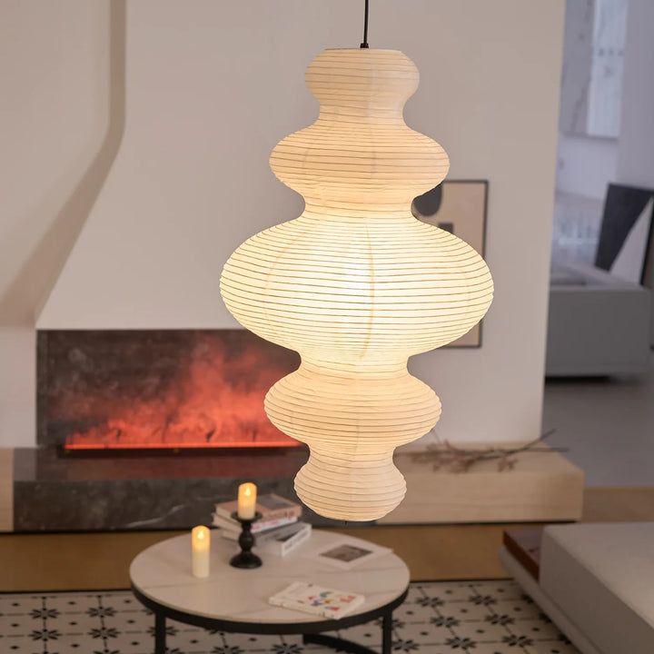 Tiered gourd paper pendant beside a modern fireplace in a warm lounge