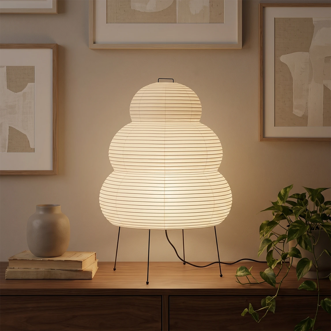Tiered paper table lamp on a console beneath framed wall art