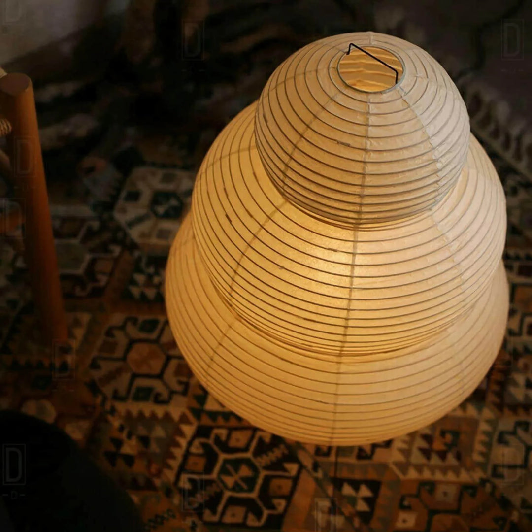 Tiered paper table lamp lit with a warm glow on a styled tabletop