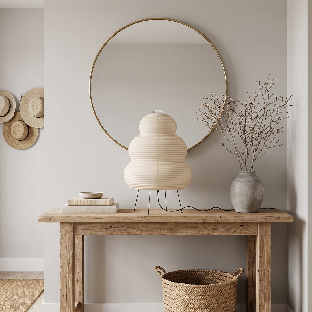 Tiered paper table lamp glowing on a side table beside a sofa in a moody room