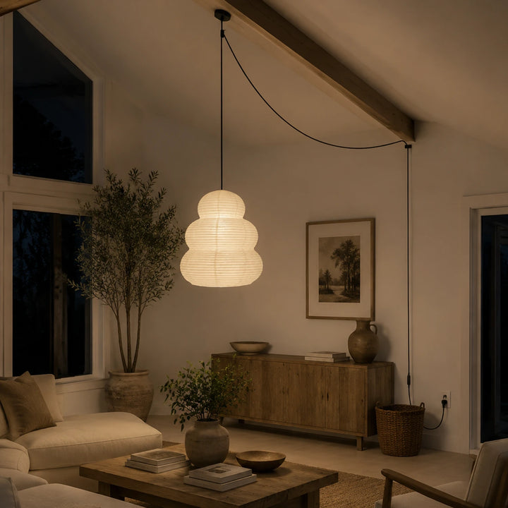 Tiered paper pendant hung from a beam in a warm living room