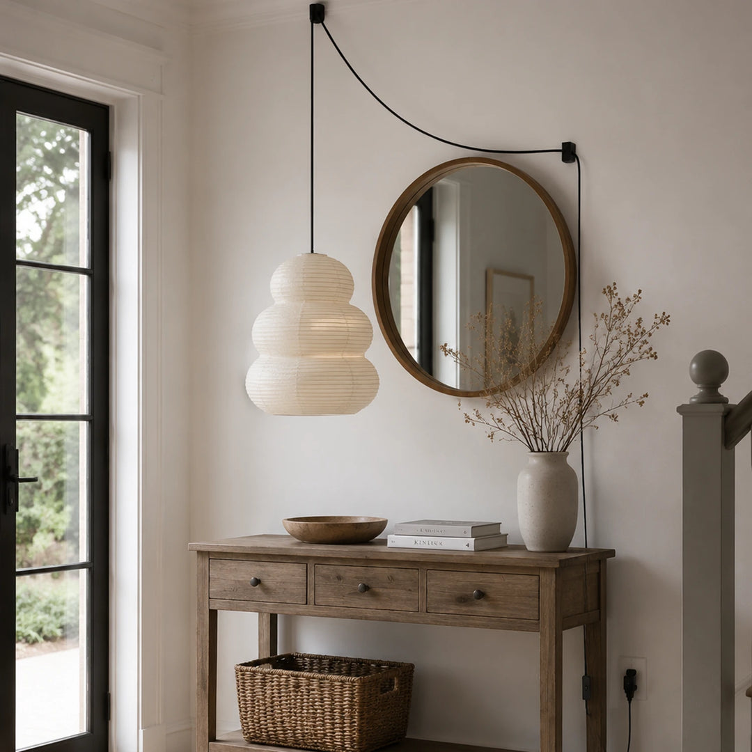 Tiered paper pendant above an entry console beneath an arched mirror