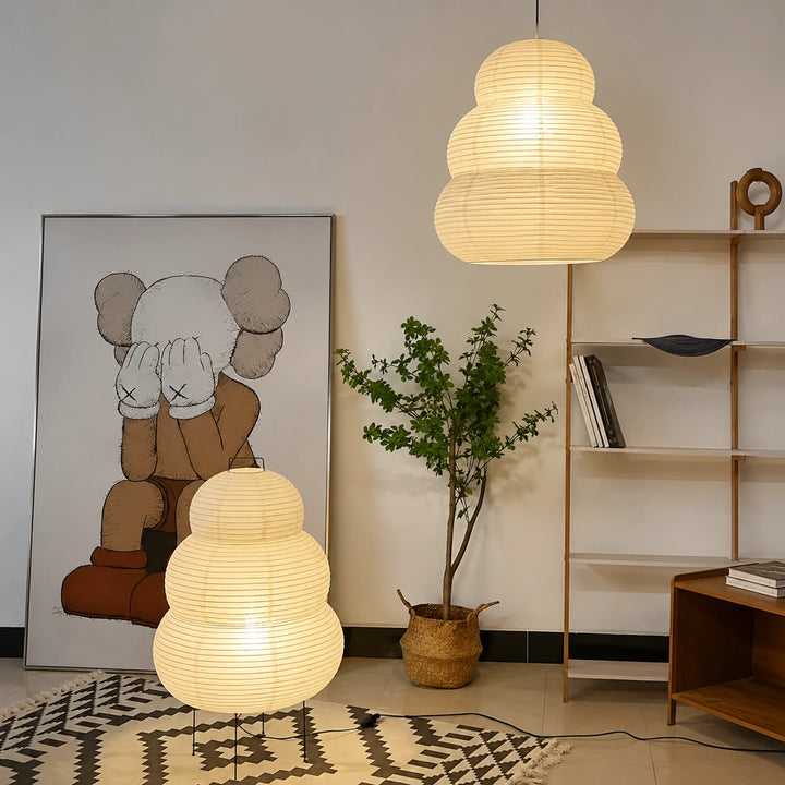 Tiered paper pendant paired with a matching floor lamp beside gallery art