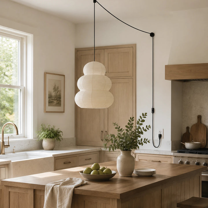 Tiered paper pendant above a kitchen island with a potted plant