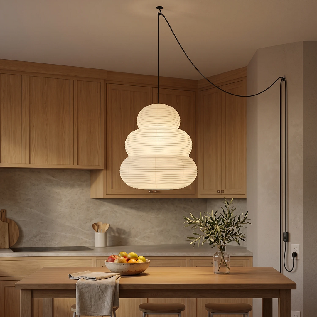 Tiered paper pendant glowing above a wooden kitchen island