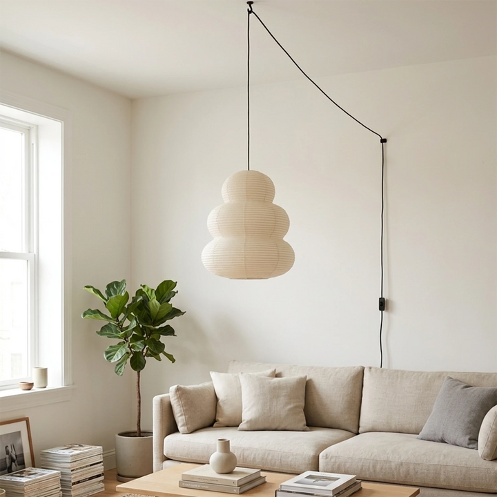 Tiered paper pendant in a daylit living room above a sectional sofa