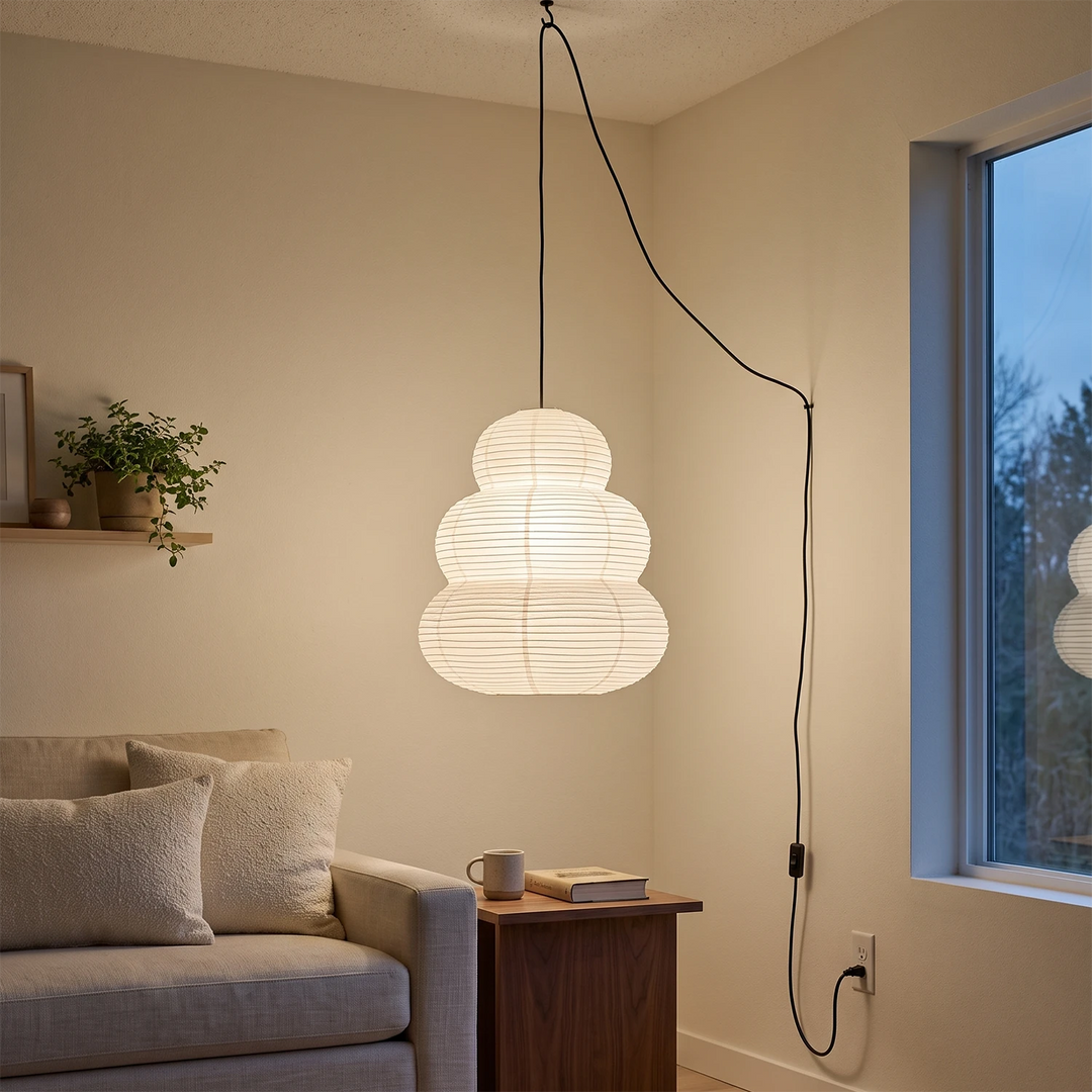 Tiered paper pendant glowing softly in a moody bedroom corner