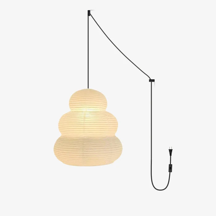 Tiered paper pendant on a black swag cord with plug, shown lit warm white
