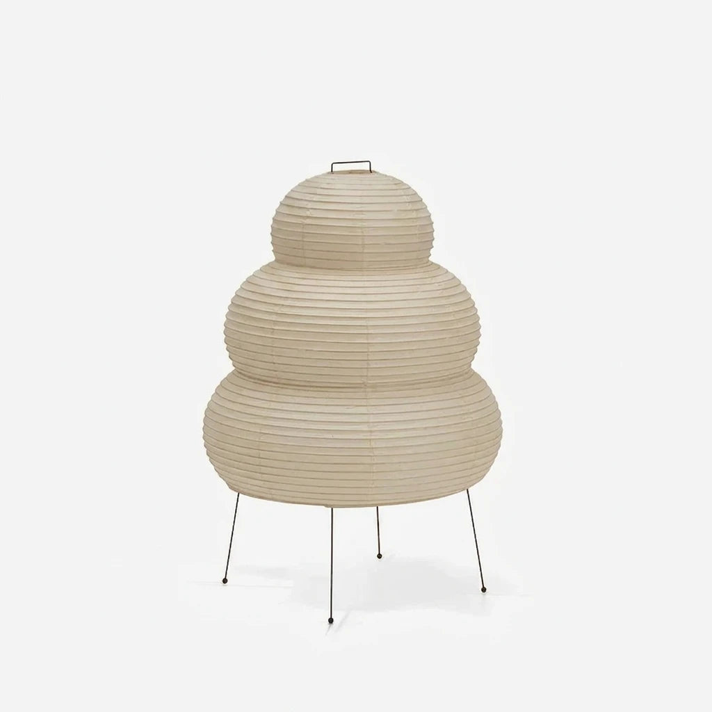 Tiered stacked mulberry paper table lamp with a tripod base on a soft grey background